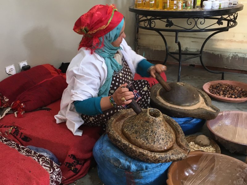 Moroccan woman grinding argan seeds Moroccan woman grinding argan seeds