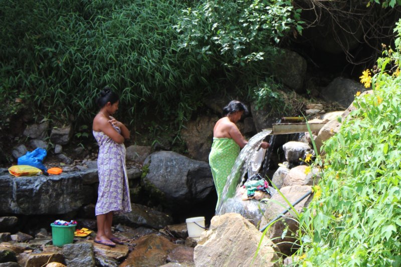 Washing clothes in a waterfall Washing laundry in waterfall, Sri Lanka tea country