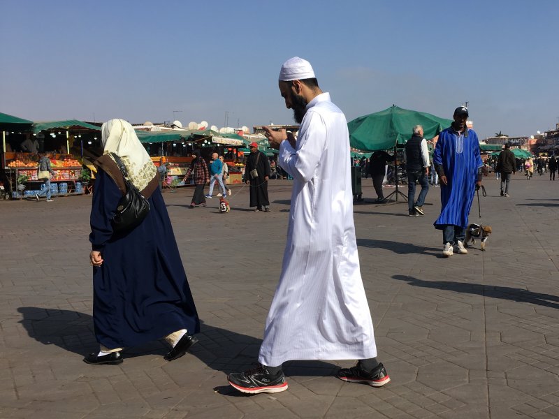 Man and his phone crossing Jemaa el-Fna Man and his phone crossing Jemaa el-Fna
