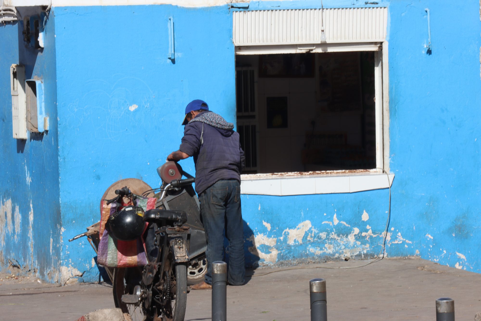 A blue house, man and motor bike A blue house, man and motor bike