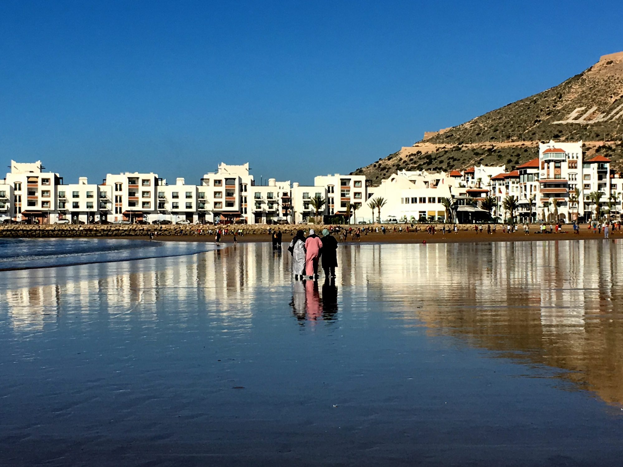 Local women walking on Agadir beach Local women walking on Agadir beach